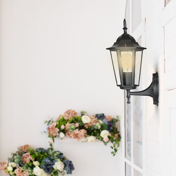 Schwarze Außenwandleuchte im klassischen Design neben Blumenschmuck