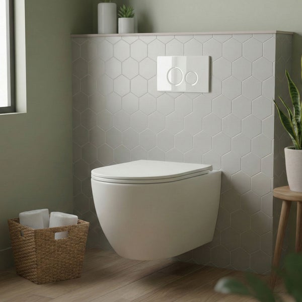 Wandhängendes WC mit Spültaste in einem Badezimmer mit Sechseckfliesen