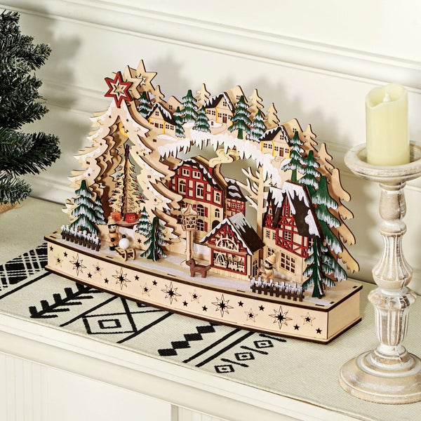 Weihnachts-Dekoration aus Holz mit Winterdorf-Motiv, Fachwerkhäusern, verschneiten Tannen und Sternen.
