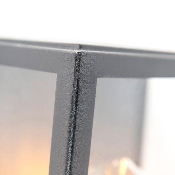 Nahaufnahme der Ecke einer schwarzen Außenleuchte aus Metall mit strukturierter Oberfläche.