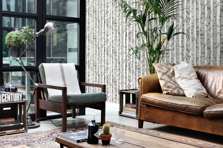 Wohnzimmer mit Sessel, Ledersofa, Stehlampe und Birkenmuster-Tapete