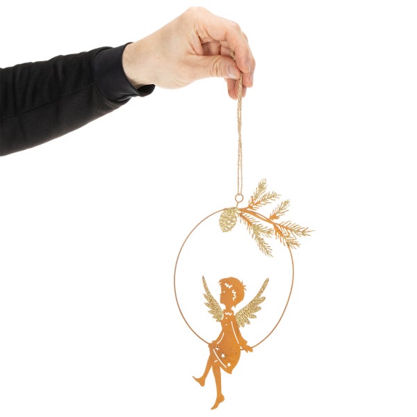 Hand hält Weihnachtsanhänger aus Metallring mit sitzendem Engel und Tannenzweig in Edelrost-Optik mit Glitzer.