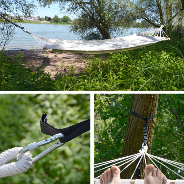 Stabhängematte mit Spreizstab zwischen Bäumen am Wasser montiert, inklusive Befestigungsset mit Gurt und Karabiner.