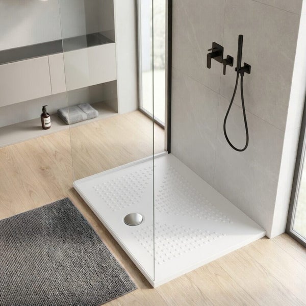 Flache, rechteckige Duschwanne mit strukturierter Antirutsch-Oberfläche in einem modernen Badezimmer mit Glaswand und Armaturen.