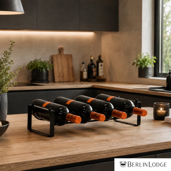 Weinregal aus Metall für vier Flaschen auf einer hölzernen Arbeitsplatte in einer modernen, elegant eingerichteten Küche.
