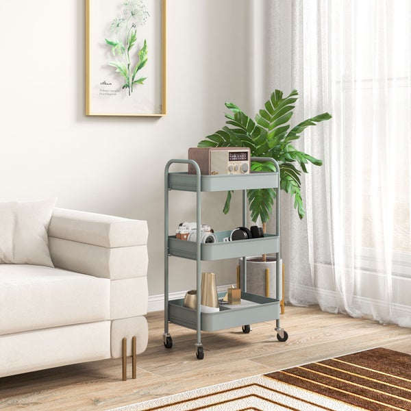 Hellblauer dreistöckiger Rollwagen aus Metall in einem hellen Wohnzimmer neben einem Sofa und einer Zimmerpflanze.