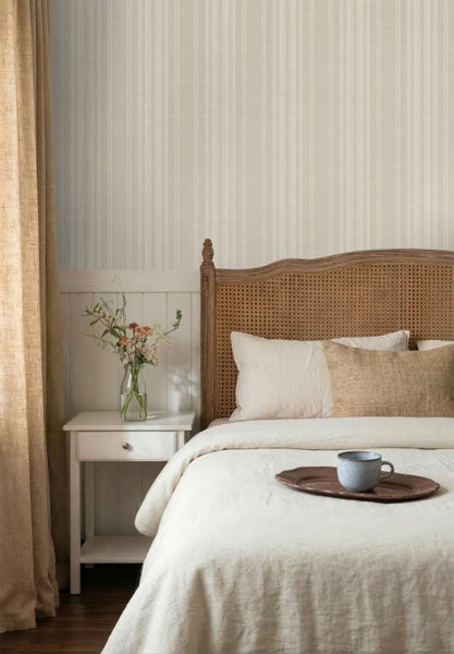 Schlafzimmer mit gestreifter Vliestapete, Holzmöbeln mit Rattan und heller Bettwäsche in wohnlicher Umgebung