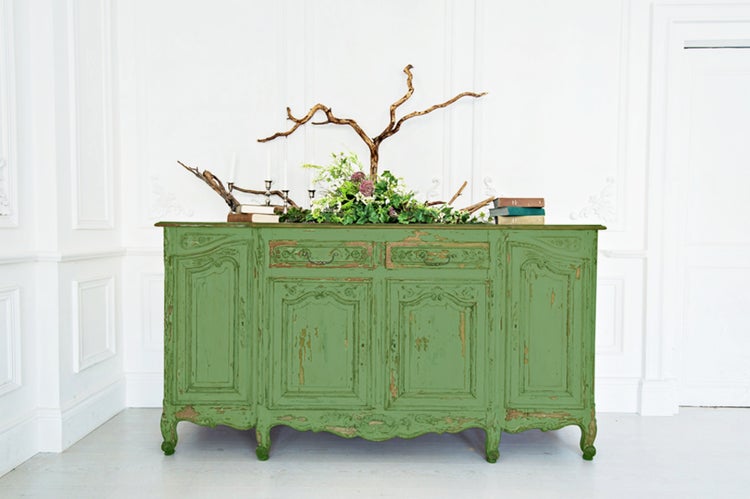 Antikes Sideboard mit Schubladen und Türen, dekoriert mit Blumen und Ästen