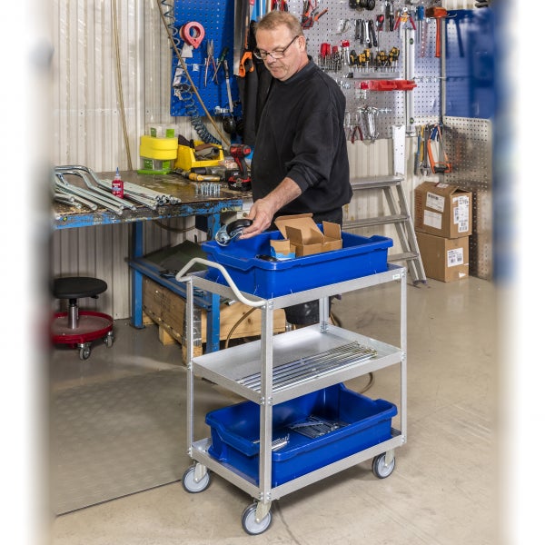 Werkstattszene mit Monteur und Werkzeugwagen mit drei Ablagen