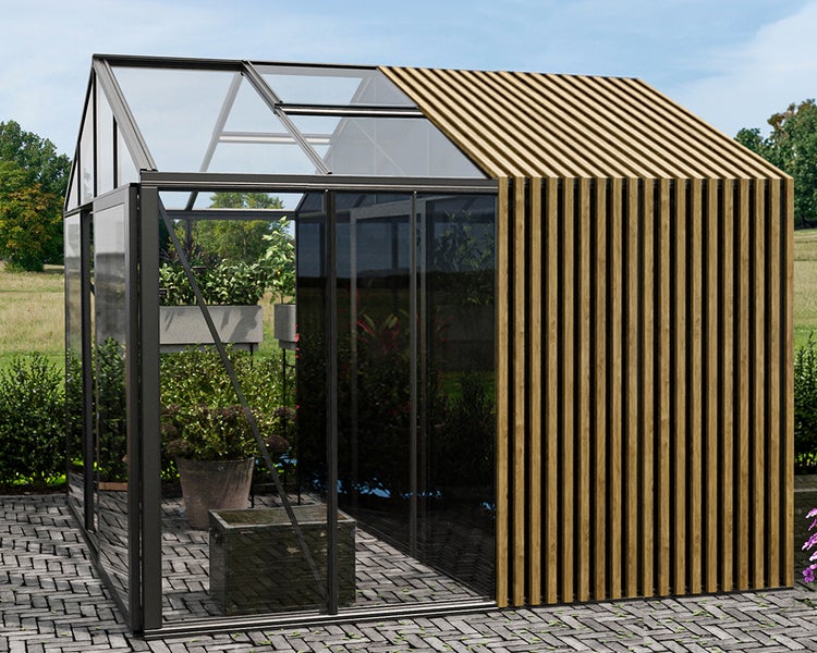 Modernes Gewächshaus mit dunklem Metallrahmen, Glaselementen und vertikalen Holzlamellen auf einer gepflasterten Terrasse.