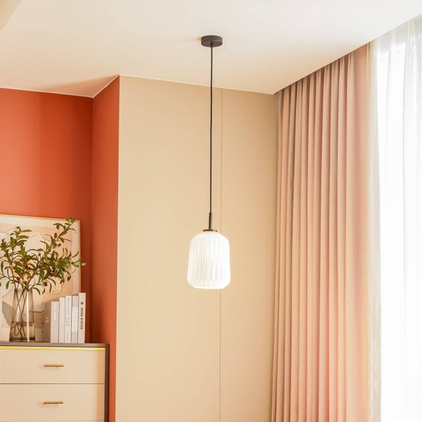 Hängelampe mit geripptem Glasschirm in einem Wohnraum