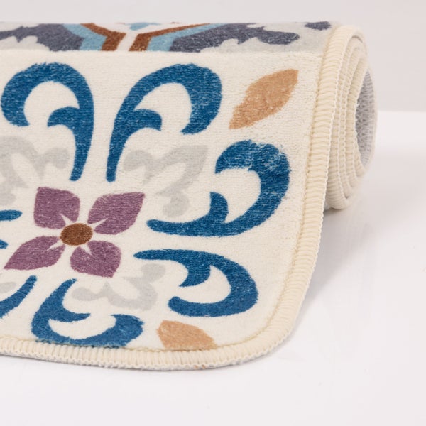 Zusammengerollter Teppich mit floralen Ornamenten und geketteltem Rand.