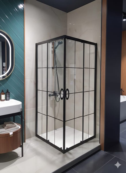 Eckdusche mit schwarzem Rahmen und klaren Glasscheiben in einem Badezimmer