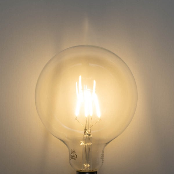 Leuchtende LED Globe-Lampe mit Glas-Kolben und sichtbaren Filament-Stäben für warmweißes Licht.
