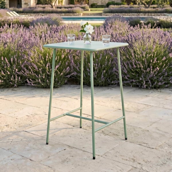 Quadratischer Stehtisch aus Metall auf einer Steinterrasse vor einem Garten mit Lavendelbüschen und Pool.