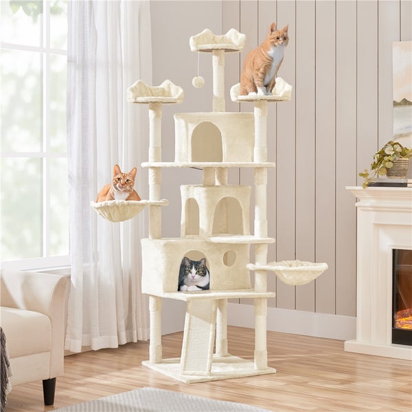 Katzenkratzbaum mit mehreren Ebenen, Höhlen und Liegeflächen in einem Wohnzimmer mit drei Katzen.