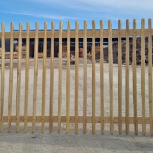 Lattenzaun aus Holz mit abgerundeten Spitzen und horizontalen Querriegeln.