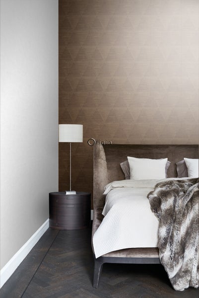 Schlafzimmer mit brauner Tapete, Bett und Nachttischlampe.