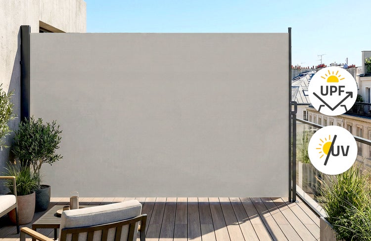 Ausziehbare Seitenmarkise auf einem Balkon mit Holzdeck, bietet Sichtschutz und Schutz vor Ultraviolett-Strahlung für Terrasse oder Garten.