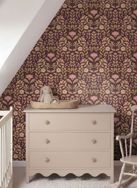 Kinderzimmer mit floral gemusterter Tapete, Kommode und Kinderbett