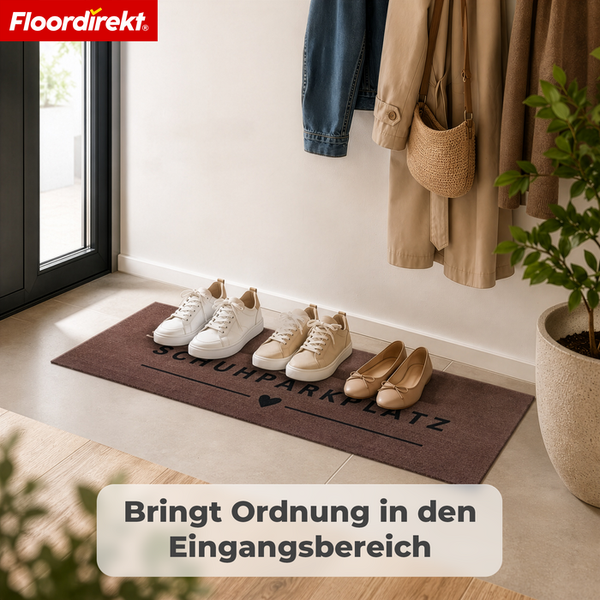 Floordirekt Logo, schmale Fußmatte mit Aufschrift Schuhparkplatz und Herz in einem aufgeräumten Flur mit Garderobe und abgestellten Schuhen.