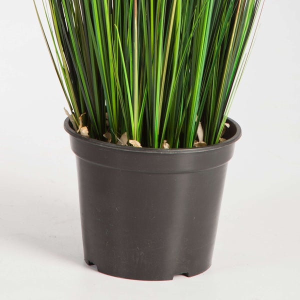 Künstliches Ziergras in einem dunklen Kunststofftopf, Detailansicht.