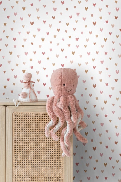 Dekoratives Kinderzimmer mit Wandtapete mit Herzmuster, Kommode und Plüschtier-Oktopus