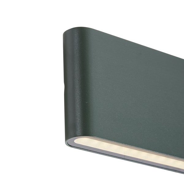 Moderne LED Außenwandleuchte in Dunkelgrün mit abgerundetem Gehäuse und warmweißem Lichtaustritt nach unten.