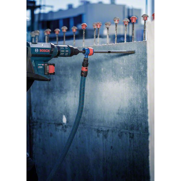 Bosch Logo. Bohren mit einem Bohrhammer in eine Betonwand mit Staubabsaugung.