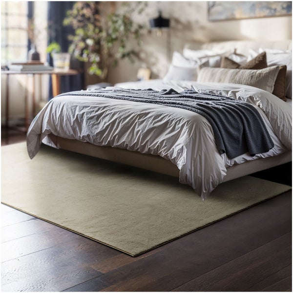 Rechteckiger Teppich unter einem Bett im Schlafzimmer auf Holzboden, weiche Textur, modernes Design.
