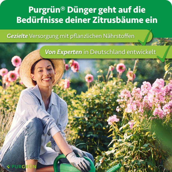 Eine lächelnde Frau mit Strohhut gießt Pflanzen in einem blühenden Garten als Werbung für Purgrün Zitrusdünger.