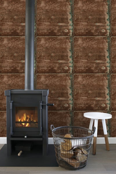 Kaminofen mit Holzkorb und Beistelltisch vor einer Wand mit Paneel Tapete