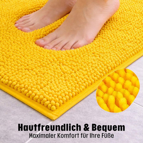 Füße auf einer weichen gelben Chenille-Badematte mit Detailansicht der Faserstruktur.