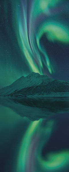 Nordlichter über einem verschneiten Berg, reflektiert im Wasser