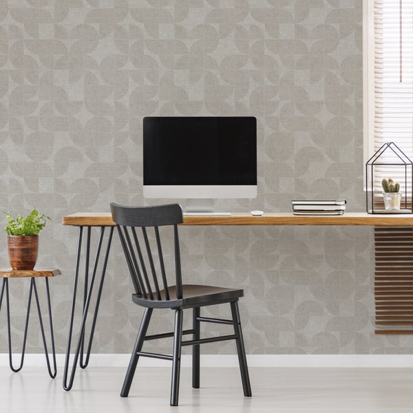 Moderne Tapete mit geometrischem Kreismuster im hellen Arbeitszimmer mit Holztisch, schwarzem Stuhl und Computer.