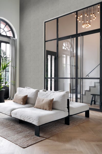 Wohnzimmer mit Sofa, Teppich und dekorativer Wandtapete