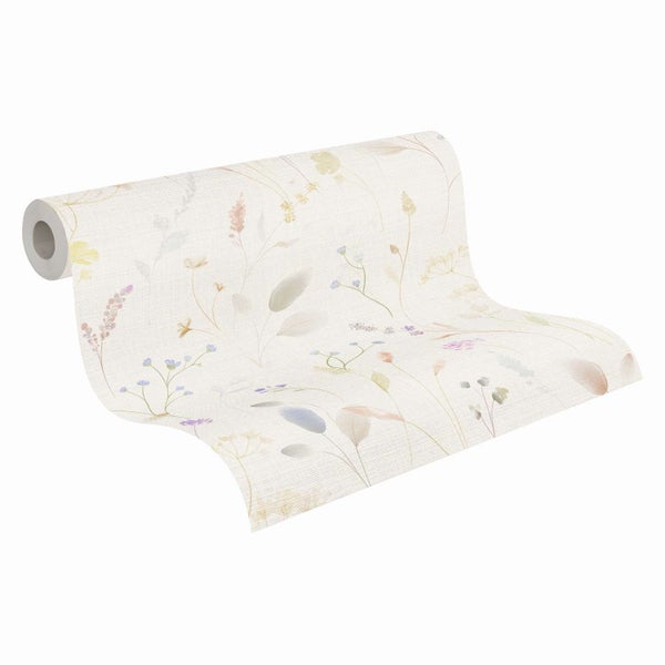 Eine Vliestapete mit zartem Wiesenblumenmuster auf einer Tapetenrolle.
