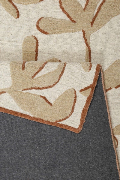 Handgetufteter Teppich mit Blättermuster, Detailansicht der weichen Oberflächenstruktur und der Textilrückseite.