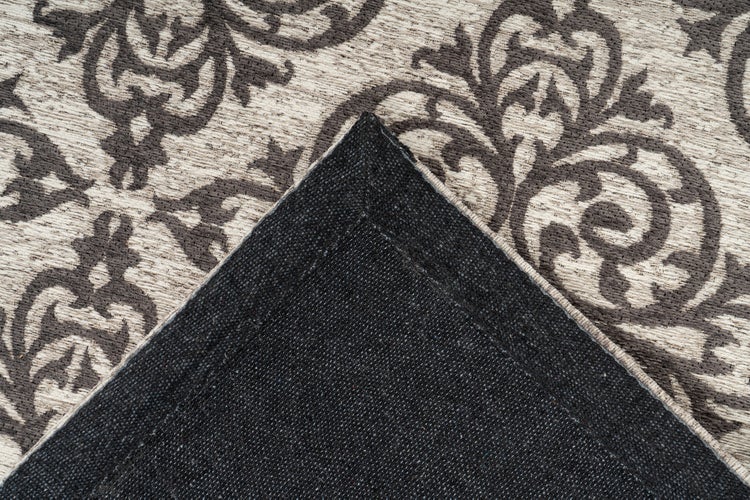 Teppich mit Ornamentmuster und umgeschlagener Ecke zur Ansicht der Rückseitenstruktur.