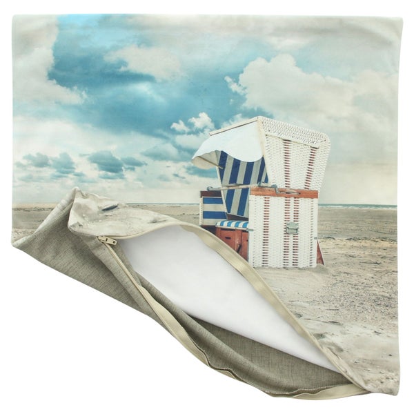 Kissenhülle mit Strandkorb-Motiv am Strand unter bewölktem Himmel mit Reißverschluss.