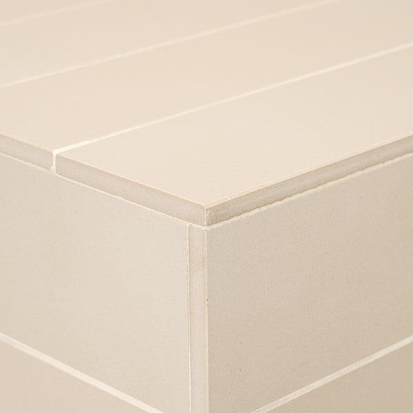 Beige Fliese mit glatter Oberfläche in Nahaufnahme als Teil einer verfliesten Ecke.