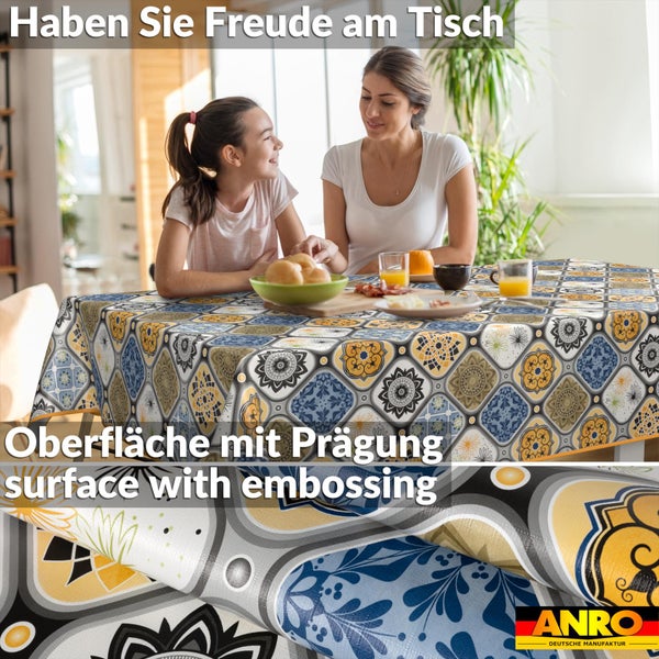 Esstisch mit ornamentaler Tischdecke mit geprägter Oberfläche. Zwei Personen sitzen am Tisch in einem hellen Raum. ANRO Logo.