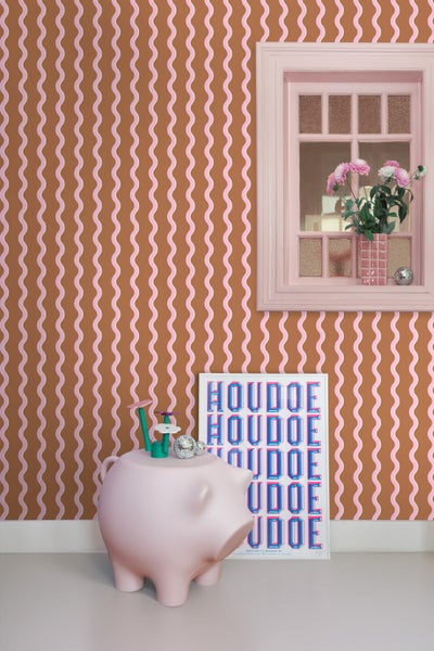 Zimmeransicht mit gemusterter Tapete, Fensterrahmen und dekorativen Objekten