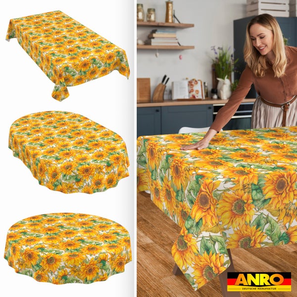 Tischdecke mit Sonnenblumenmuster in rechteckiger, ovaler und runder Form, Frau in heller Küche an Holztisch, ANRO DEUTSCHE MANUFAKTUR Logo.