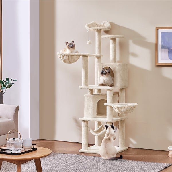 Katzenkratzbaum mit mehreren Ebenen und drei Siamkatzen in einem Wohnzimmer.