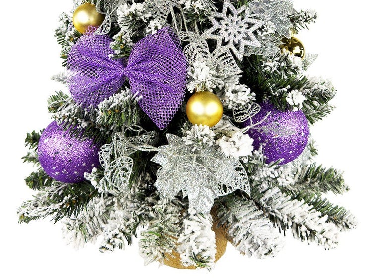 Künstlicher Weihnachtsbaum mit künstlichem Schnee, Kugeln, Schleifen und Sternen als Dekoration für eine festliche Weihnachtsdekoration.