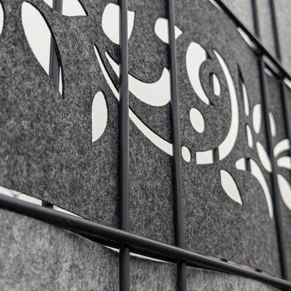 Detailansicht eines grauen Sichtschutzzauns mit dekorativen Ausschnitten im Stoff