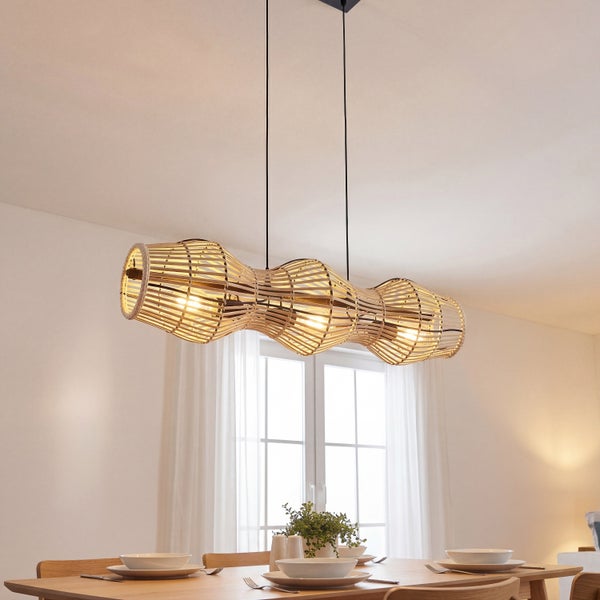 Dreiflammige Pendelleuchte aus Bambus mit geschwungenem Schirm über einem Esstisch aus Holz in einem hellen, modern eingerichteten Raum.
