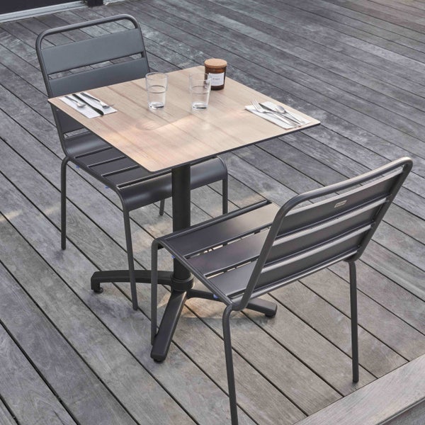 Modernes Bistro-Set bestehend aus einem quadratischen Tisch in Holzoptik und zwei Metallstühlen auf einer Holzterrasse.