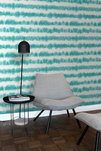 Innenraum mit gemusterter Tapete, Sessel und Stehlampe